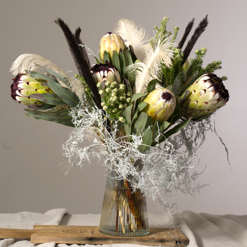 winter stem edit arrangement of white proteas and other foliage